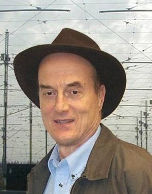 pictured - speaker Paul A. Bernhardt wearing a brown cap, blue dress shirt, and brown jacket