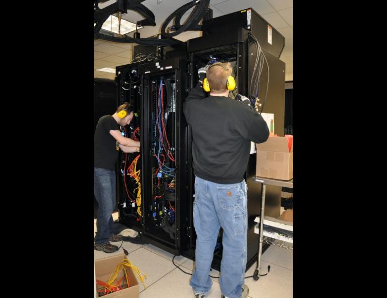 Tim Slauson, left, and Liam Forbes install components to increase the capacity of the Chinook computer system in February 2017. Chinook is operated by Research Computing Systems at the University of Alaska Fairbanks Geophysical Institute. Photo courtesy of UAF GI Research Computing Systems.