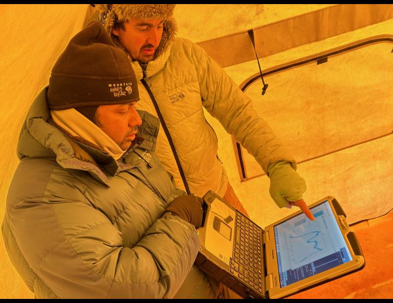 UAF postdoctoral fellow Achille Capelli and Ph.D. student Thimira Asurapmudalige look at data obtained by their Lightweight Airborne Snow and Sea Ice Thickness Observing System. Photo by Rod Boyce