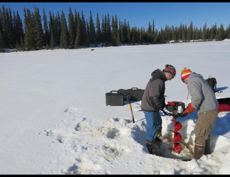 Chris Arp and Ben Gaglioti maneuvering an auger on the pond ice. 