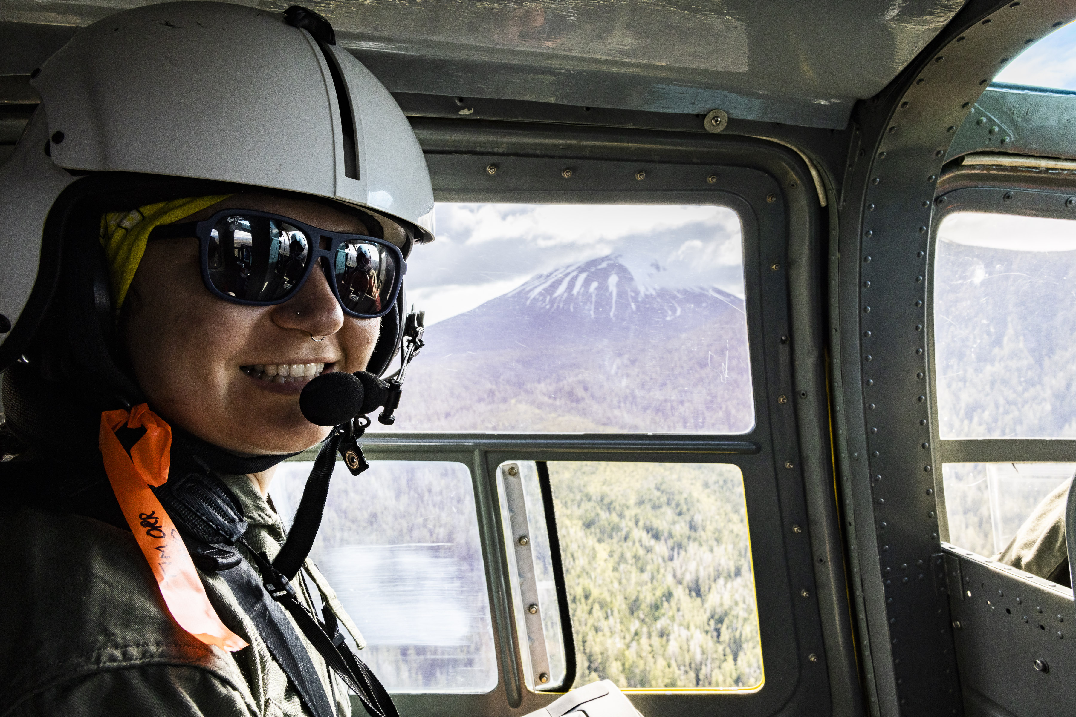 Claire Puleio, graduate student researcher at the Geophysical Institute, rides in a helicopter during field work.