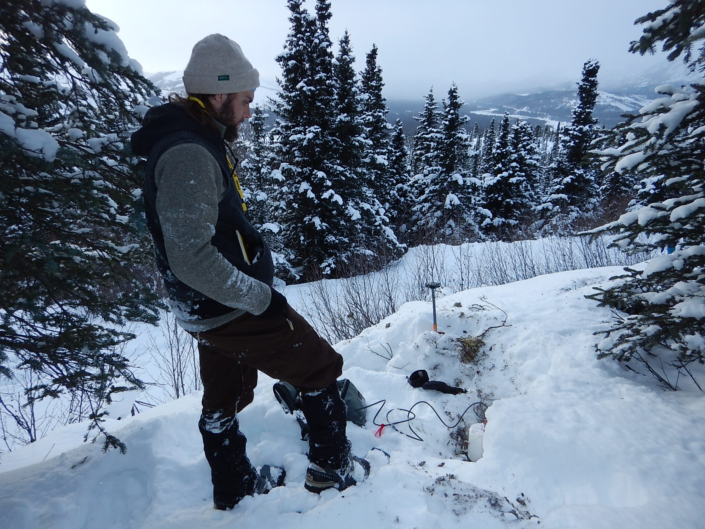 UAF graduate student Cole Richards installs a high-sampling seismic sensor in February 2019. It is one 400 placed along the Parks Highway following the 2018 magnitude 7.1 Anchorage earthquake. Graduate student Bella Seppi would later use the sensor data in her aircraft research. Photo by Carl Tape