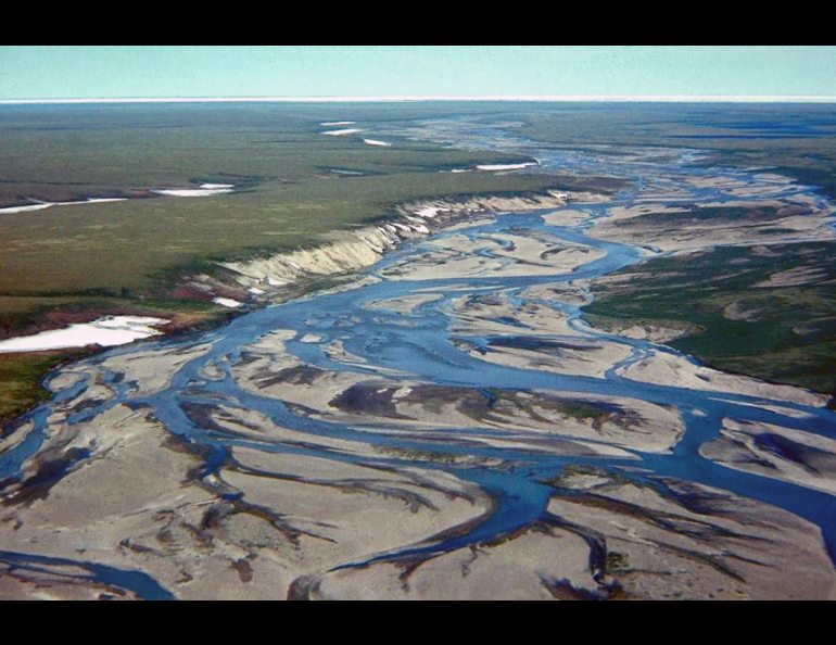 The Jago River flows north through the Arctic National Wildlife Refuge to the Arctic Ocean, with its ice pack visible in the distance in the 1990s. Image by Gil Mull, Alaska DGGS.