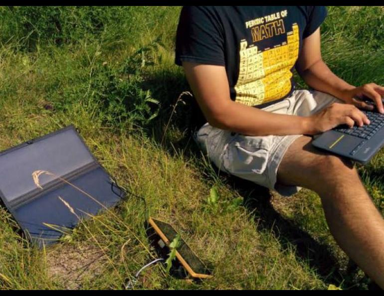 Ianjon Brower tests a solar-powered prototype of a computer that can monitor ice cellars while sitting outside of the University of Alaska Fairbanks’ Geophysical Institute. Photo by Vanessa Raymond.
