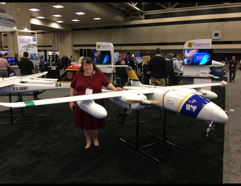 Cathy Cahill, director of the Alaska Center for Unmanned Aircraft Systems Integration, with UAF’s Griffon Aerospace Outlaw SeaHunter UAS at a conference. Photo courtesy Alaska Center for Unmanned Aircraft Systems Integration.