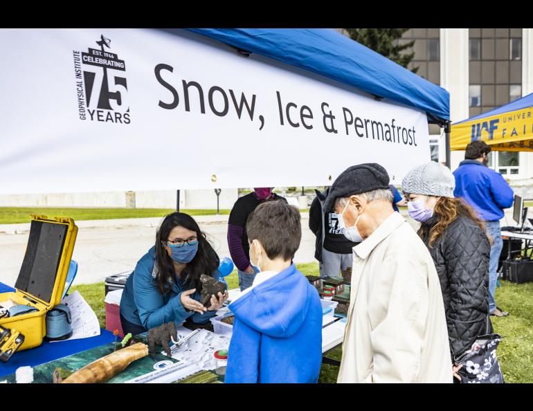 Several GI units staffed booths with science activities at the GI's 75th anniversary celebration. Margaret Rudolf explains the display to Syun-Ichi Akasofu and his grandchildren. UAF photo by JR Ancheta.