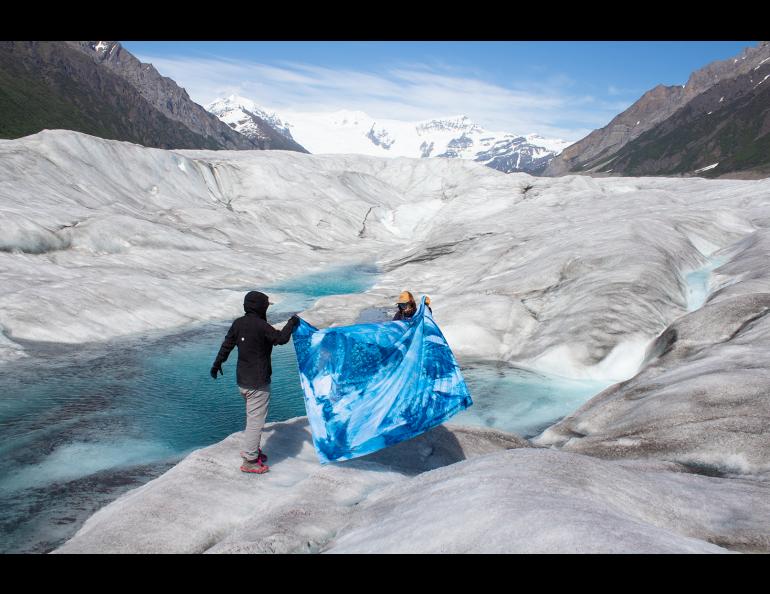 Nina Elder and Hannah Perrine Mode hold a fabric cyanotype that Mode created on the Kennicott Glacier. Photo by Tyler Rai