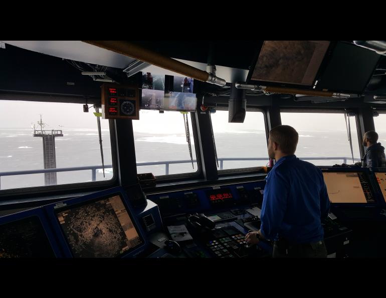 A break in the clouds allows the Sikuliaq crew to use GINA-provided visible images to navigate around larger ice floes. The ice radar display is visible in the lower left. The map server monitor is top center and the image shown is a Terra true color. Photo by Steve Roberts