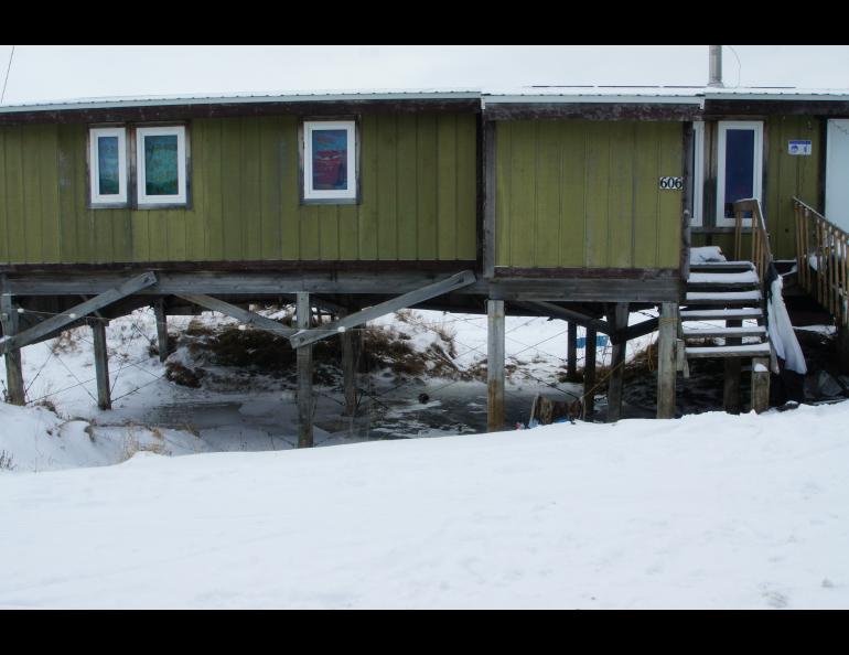 The amount of subsidence can be inferred by the distance from the bottom step to the ground in this photo of a building in Point Lay, Alaska. Photo courtesy of Bill Tracey.