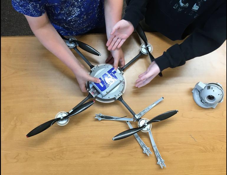 Students get hands-on activity at an education outreach session at Delta Junction Junior High School in July. Here, two students reassemble a drone that Adkins has taken apart. Photo by Rod Boyce