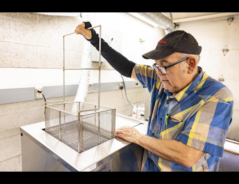 Jesse Atencio of the Geophysical Institute demonstrates the process of washing, curing and firing metal prints at the welding shop located in the Elvey Building at the University of Alaska Fairbanks. Photo by JR Ancheta