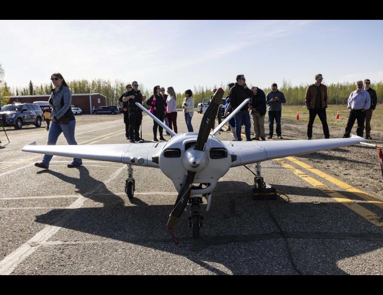 Event participants gather around the Sentry unmanned aircraft of the UAF Alaska Center for Unmanned Aircraft Systems Integration after a successful flight May 22, 2022, at Fairbanks International Airport. Photo by JR Ancheta/UAF Geophysical Institute