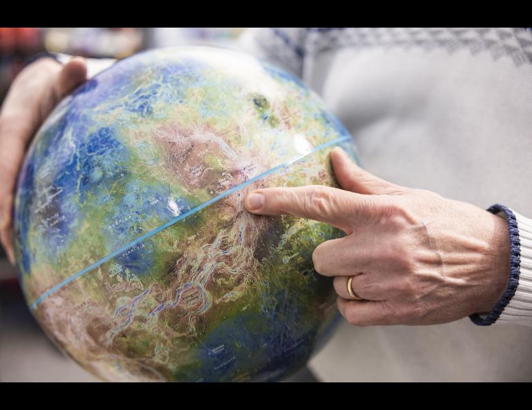 Research professor Robert Herrick points to the location of his research on a Venus globe in his office at the University of Alaska Fairbanks West Ridge Research Building in Fairbanks, Alaska. UAF/GI photo by JR Ancheta.