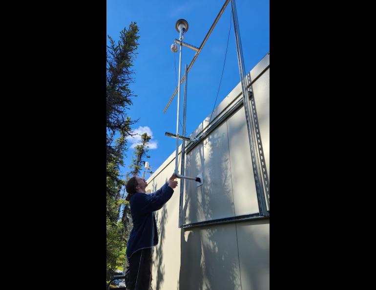 Graduate student James Campbell installs the sampling inlet for the X-act instrument outside at the Delta Junction network site. Photo courtesy of Jingqiu Mao.