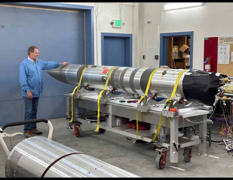 Geoff Reeves of Los Alamos National Laboratory stands in the Poker Flat Research Range payload assembly area with the upper portion of the four-stage NASA sounding rocket that will carry his Beam-PIE science instruments. Reeves is the experiment’s principal investigator. Photo by Rod Boyce