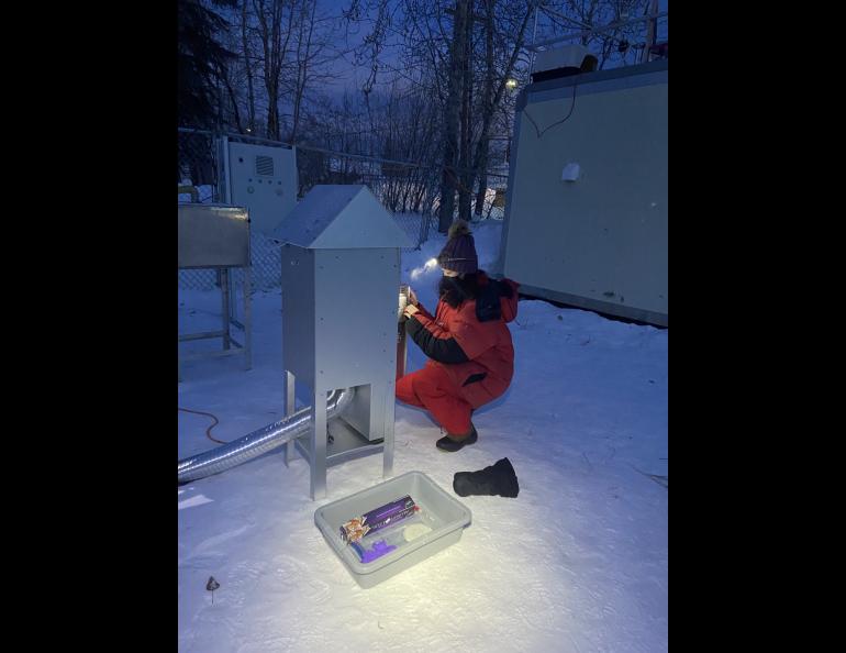  Shuting Zhai, a co-author on the sulfate paper and recent University of Washington Ph.D. graduate, collects filters from an air sampler in the 2022 research campaign in Fairbanks. Photo courtesy of Allison Moon. 
