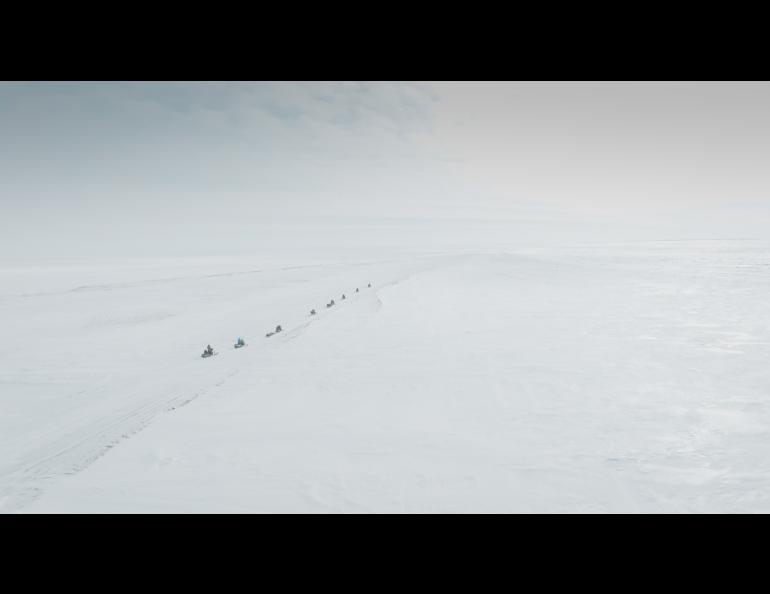 The train of snowmachines heads back to Utqiagvik. Photo by Bryan Whitten