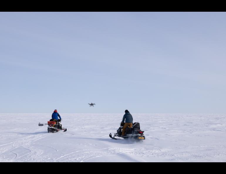 Associate Professor Hans-Peter Marshall of Boise State University, left, follows the Boise State drone, which is carrying a radar. His snowmachine is mounted with a ground-penetrating radar. UAF Research Professor Andy Mahoney is at right. Photo by Bryan Whitten