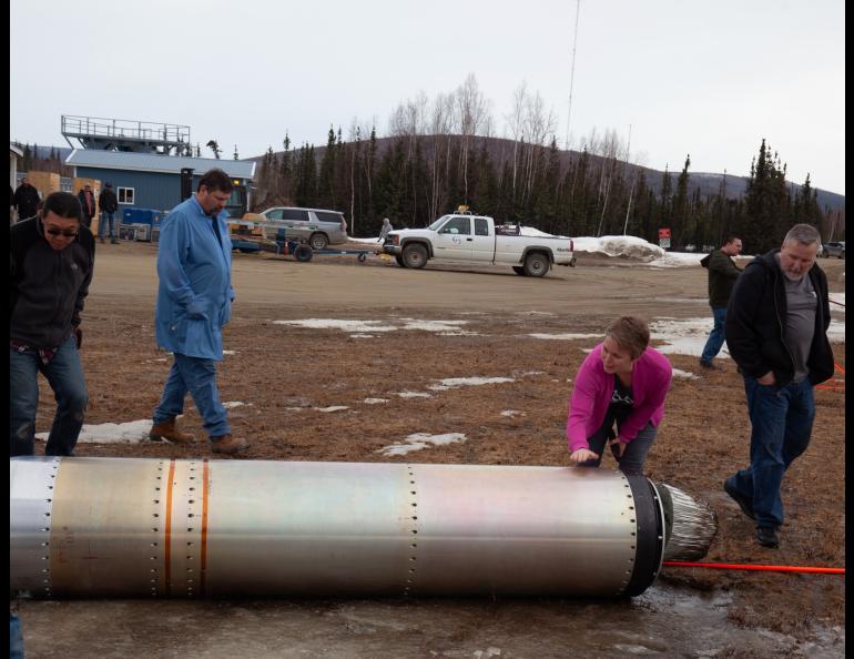Astrophysicist Sabrina Savage of NASA’s Marshall Space Flight Center gives a "well done" pat to a recovered portion of a rocket launched April 17, 2024, from Poker Flat Research Range as part of NASA's new solar flare sounding rocket campaign. NASA photo