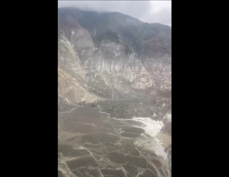 Debris from an Aug. 10, 2025, landslide in Southeast Alaska spilled into Tracy Arm and onto South Sawyer Glacier. Dirt, rock and debris now fill an area of the fjord in the lower left of the photo. Image from video by Lt. Chip Baucom and Cmdr. PJ Johansen, U.S. Coast Guard