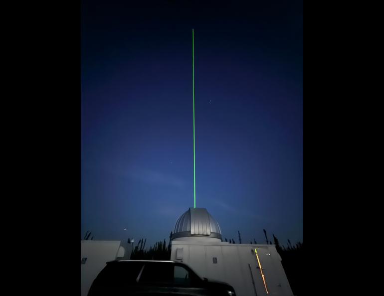 A light beam produced by the new lidar emerges from the dome at the Subauroral Geophysical Observatory at Gakona. Photo by Mike Roddewig