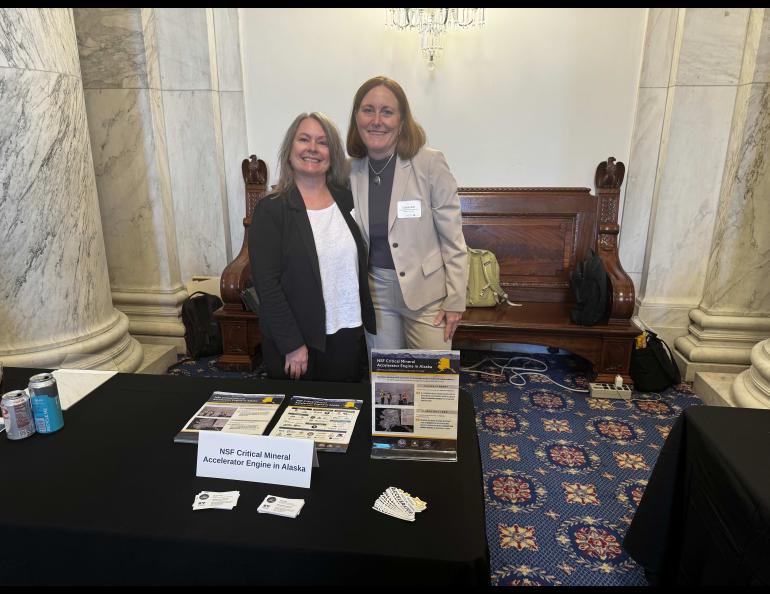Lee Ann Munk, left, chief executive officer of Alaska’s new National Science Foundation Innovation Engine, stands with strategy and innovation officer Christi Bell at an NSF announcement event in Washington, D.C. They pose behind a display table featuring materials for the project.