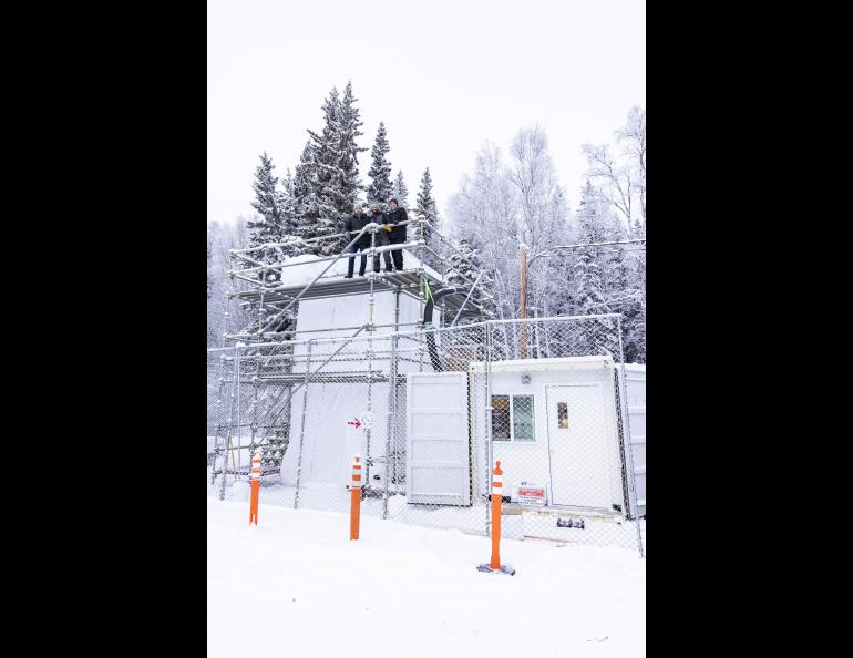  From left, Coda Consulting CEO Mathieu Gibeault, Eyal Saiet of ACUASI, and Gislain Chevrette of Coda stand atop the new icing tower at the University of Alaska Fairbanks in February 2025. The scaffold-framed tower and adjoining equipment structures sit inside a fenced, snow-covered site.