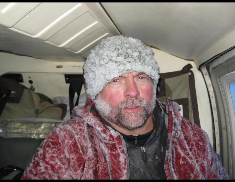 Volcano researcher John Paskievitch sits down coated in ice after three hours of creating and securing anchor points to tie off a Jet Ranger helicopter stranded by ice on the summit of Mount Mageik in the Valley of 10,000 Smokes. Photo by Taryn Lopez