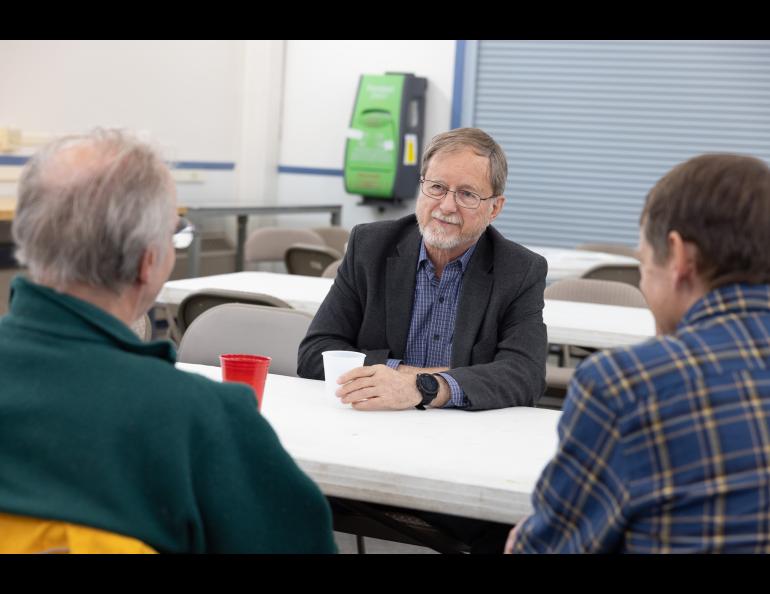 GI Director Bob McCoy chats with Hans Nielsen and Craig Heinselman during the Poker Potluck Pig Roast on Aug. 23, 2024. Photo by Bryan Whitten