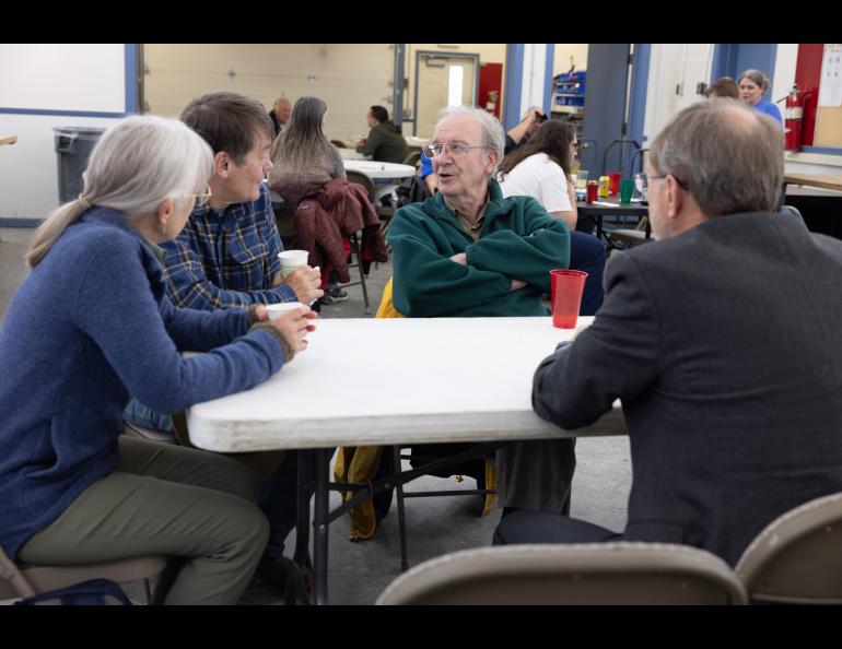 Bob McCoy chats with Hans Nielsen, Craig Heinselman and Craig's wife Denise Rust during the Poker Potluck Pig Roast on Aug. 23, 2024. Photo by Bryan Whitten