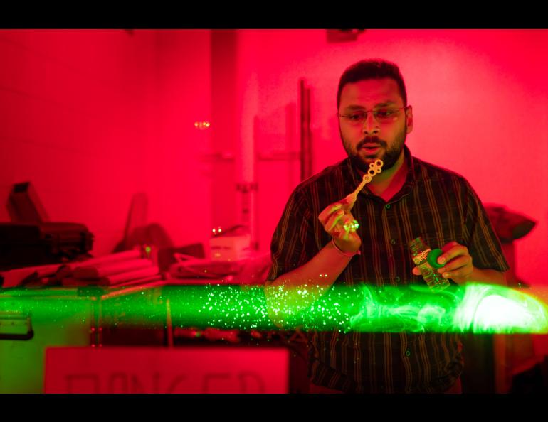 Ph.D. Student Satyaki Das demonstrates the laser beam at the Lidar Research Lab during the Poker Potluck Pig Roast on Aug. 23, 2024. Photo by Bryan Whitten