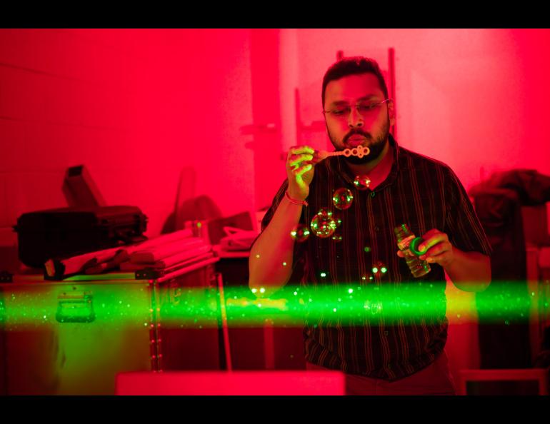 Ph.D. Student Satyaki Das demonstrates the laser beam at the Lidar Research Lab during the Poker Potluck Pig Roast on Aug. 23, 2024. Photo by Bryan Whitten