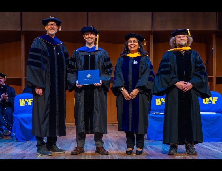 UAF Chancellor Dan White and Provost and Executive Vice Chancellor Anupma Prakash pose with David Polashenski during the 2025 Ph.D. Hooding Ceremony in the Davis Concert Hall on the UAF campus, Friday, May 2, 2025. Polashenski earned a Ph.D. in Geophysics. He is escorted by Dr. Andreas Aschwanden, right. UAF photo by Eric Engman