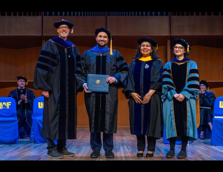 UAF Chancellor Dan White and Provost and Executive Vice Chancellor Anupma Prakash pose with Dillon Gillespie during the 2025 Ph.D. Hooding Ceremony in the Davis Concert Hall on the UAF campus, Friday, May 2, 2025. Gillespie earned a Ph.D. in Space Physics. He is escorted by Dr. Doğacan Öztürk, right. UAF photo by Eric Engman