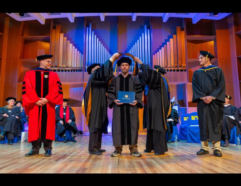 Jason Ahrns receives his hood from Chancellor Sfraga and Interim Provost Charlene Sterm while CNSM Dean Karsten Huffer and Don Hampton look on. Photo by Eric Engman