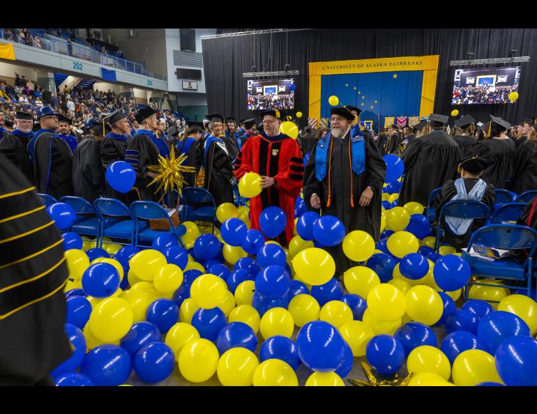 The leaders of the recessional departing the Carlson Center from the 2026 105th commencement ceremony had to wade through a sea of blue and gold balloons. Photo by Eric Engman