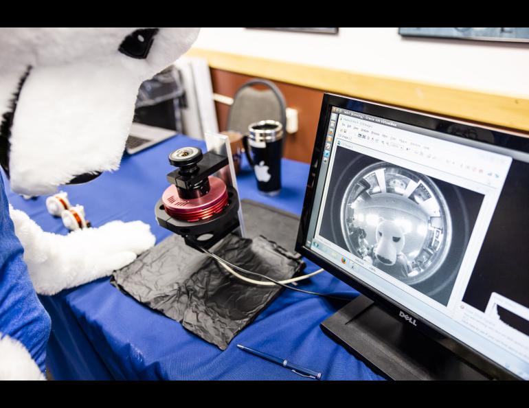 The Nook peers into the fish-eye lens of an allsky camera set up in the Globe Room of the Elvey Building during the 2023 Arctic Research Open House. UAF/GI photo by JR Ancheta.