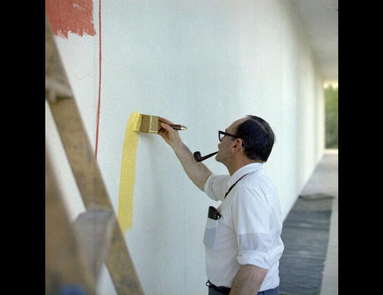 Director Keith Mather helping to paint the colorful mural which originally surrounded the Elvey Building.