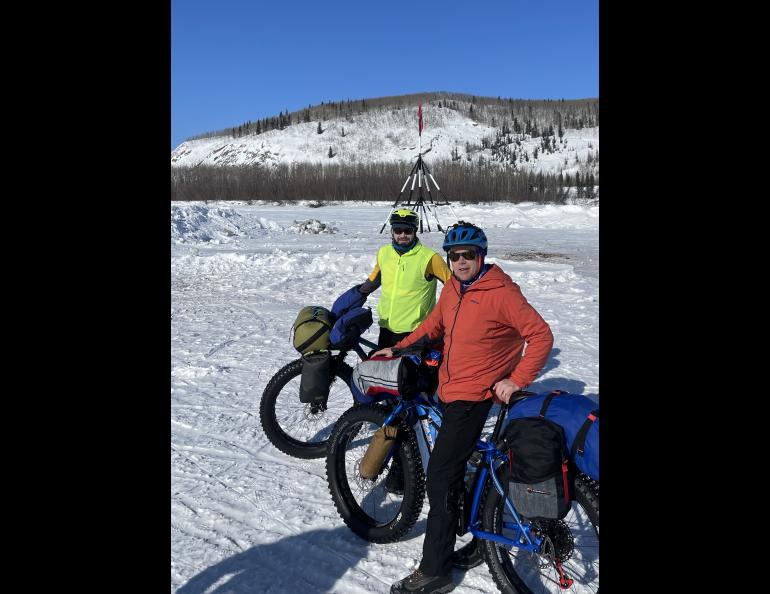 Forest Wagner, left, and Ned Rozell pause in front of the tripod on the ice of the Tanana River at the town of Nenana. When river ice breaks up, whoever guesses the exact time the tripod falls and pulls a cable will be the winner of the Nenana Ice Classic. Photo by Ned Rozell.