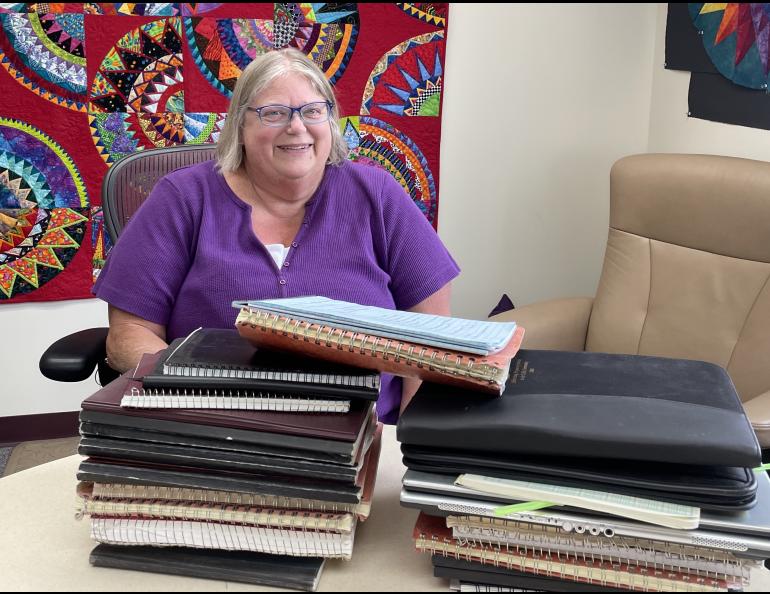 In June 2025, Kathe Rich sits in her office at Poker Flat Research Range behind notebooks she has filled with details of her 35 years at the rocket-launching facility. Photo by Ned Rozell.