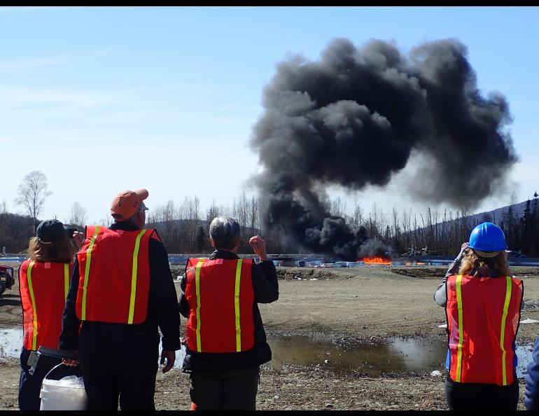 A group of researchers watch an experimental burn of crude oil in a manmade basin at Poker Flat Research Range in April 2015. Photo by Ned Rozell. 