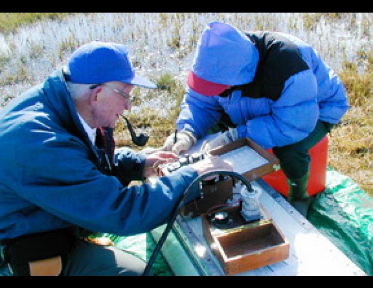  Max Brewer takes a permafrost measurement at a site near Barrow he established more than 50 years ago. With Brewer is graduate student Huijun Jin. Photo by Kenji Yoshikawa. 