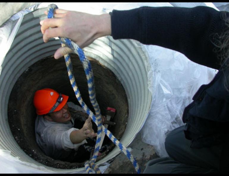 German permafrost scientist Lutz Schirrmeister of Potsdam hands a rope to Kenji Yoshikawa, a Fairbanks permafrost scientist who has drilled a 30-foot hole into a local pingo. Ned Rozell photo.