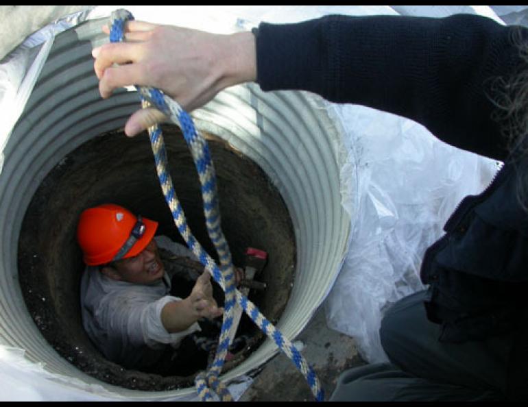  German permafrost scientist Lutz Schirrmeister of Potsdam hands a rope to Kenji Yoshikawa, a Fairbanks permafrost scientist who has drilled a 30-foot hole into a local pingo. Ned Rozell photo. 