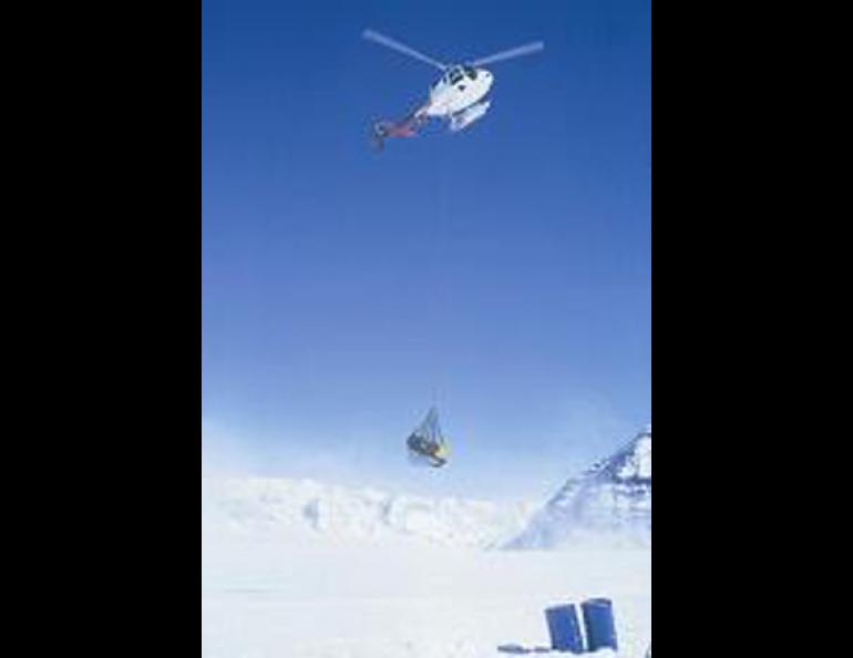  A helicopter pilot sling-loads supplies to a saddle between Mounts Bona and Churchill in eastern Alaska where Ohio State scientists pulled extracted a quarter-mile of ice. Lonnie Thompson photo. 