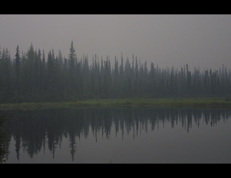 Smoke from a fire 80 miles away hangs over Ballaine lake in Fairbanks. Photo by Ned Rozell.