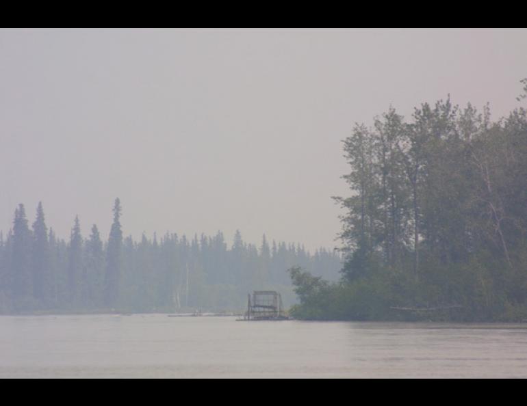 A fish wheel turns on the Tanana River on a smoky July afternoon. The Tanana, fed by water from melting glaciers and other sources, was flowing bank-to-bank while other Interior streams and rivers without glacial sources were trickling near record lows. Ned Rozell photo.
