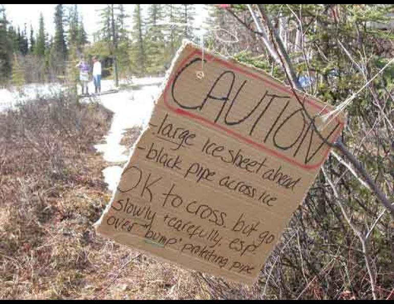 A resident of the Goldstream Valley north of Fairbanks installed this sign warning trail users of a small glacier that formed in her yard. Photo by Ned Rozell.