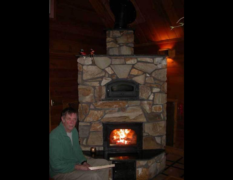  Bill Reynolds of Fairbanks next to his masonry heater. Photo by Ned Rozell. 