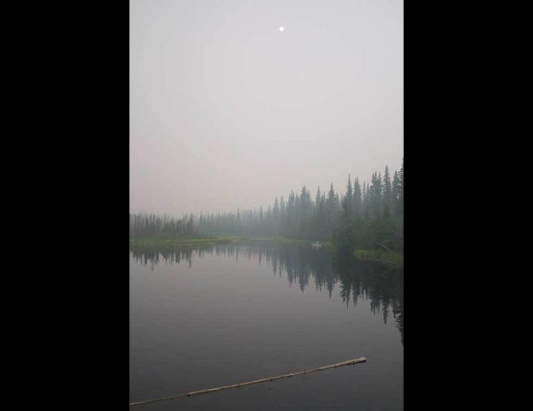 A lone canoeist at Ballaine Lake in Fairbanks on a smoky summer day in 2004. Photo by Ned Rozell, from The Climate of Alaska.